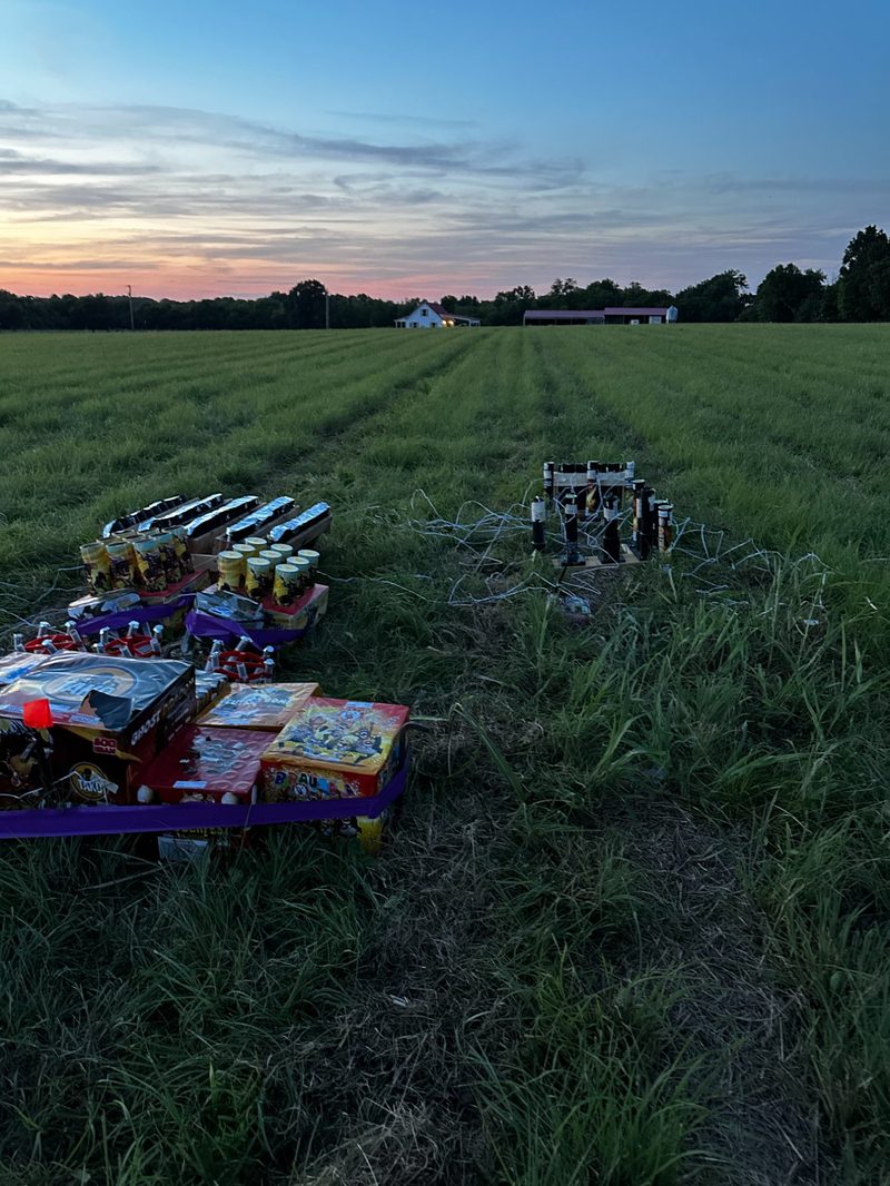 Fireworks cakes and mortar tubes pre-staged in the field at dusk