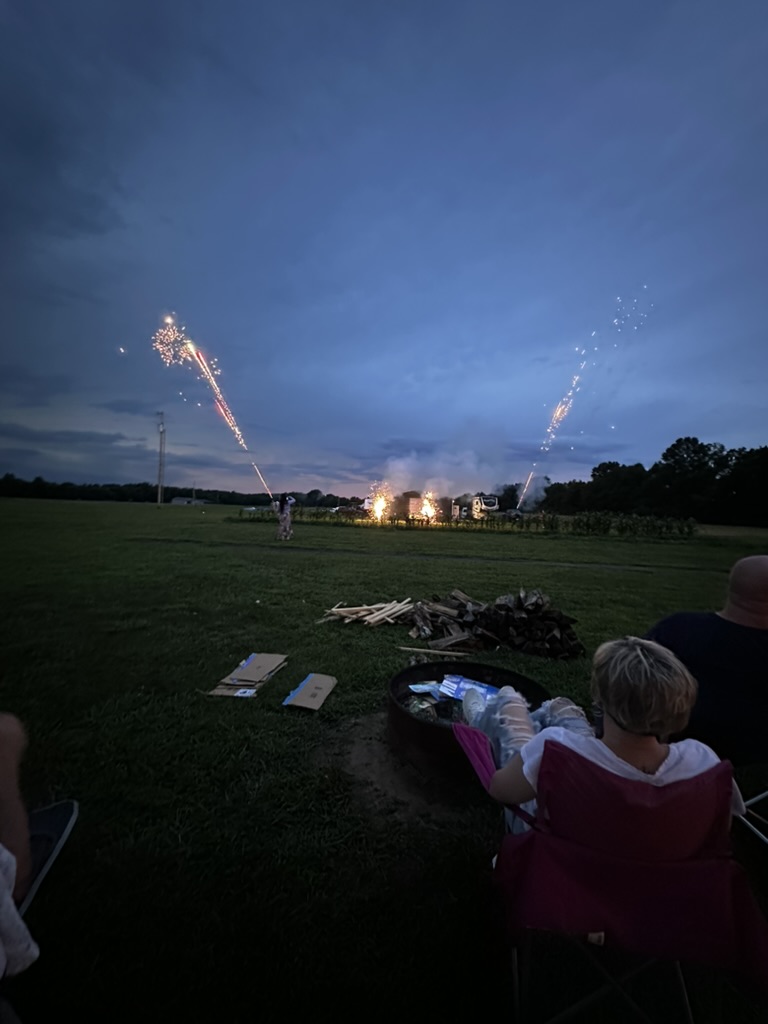 Fireworks lighting up the field at dusk