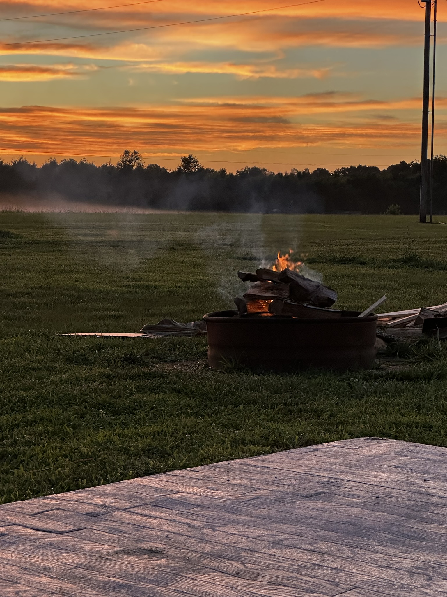 Golden hour sunset over the open field with the fire pit lit